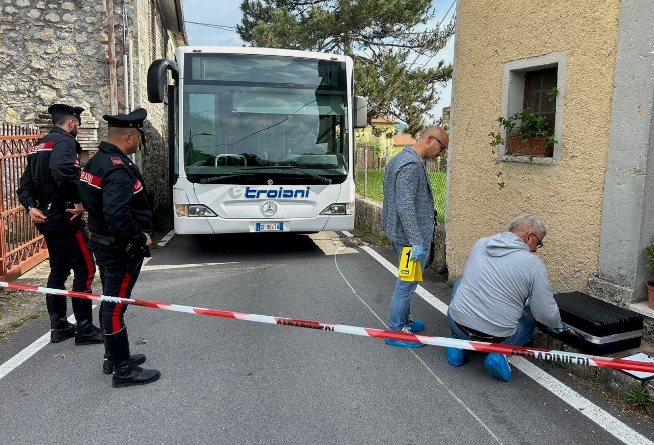 Interno di un bus vuoto con i sedili in fila e la luce del mattino che entra dai finestrini.