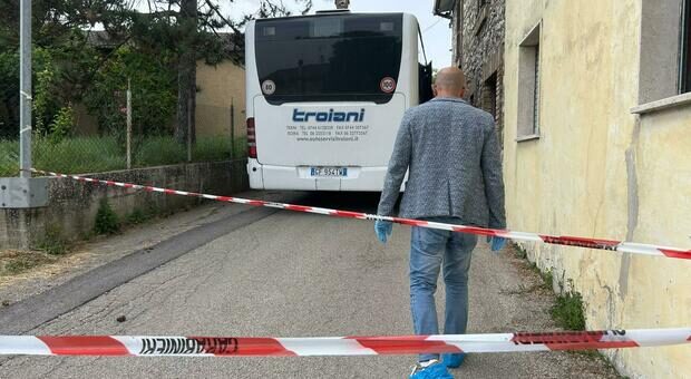 Agenti e soccorritori vicino a una fermata, con il traffico rallentato e le persone raccolte sul marciapiede.